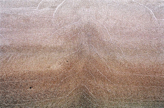 Sand-Scape.  These white patterns are created by waves depositing the finest silica  particles at the end of the waves reach.  We have about 3 miles of beach along which you can see wonderful pictures painted by the waves. 